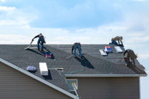 technicians on top of a home installing a new asphalt shingle roof