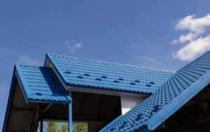 The roof of a house covered with sheets of blue metal tiles